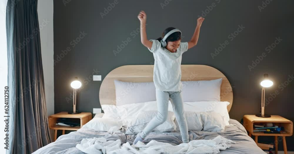 Young girl, dancing and bed at home with music and happy from song in morning. Youth, dancer and headphones with dancer and comedy in a house bedroom with a child and energy of a kid with audio