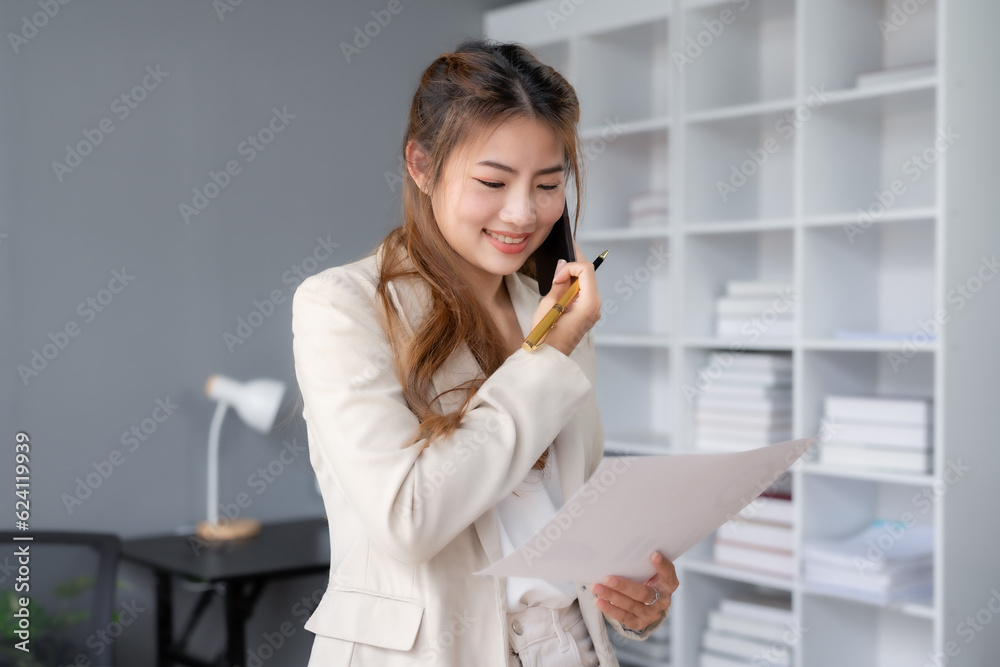 Asian businesswoman modern professional talking with client on the phone with a confident demeanor and effective communication skill. business, marketing, sale and communication project. Asian businesswoman modern professional talking with client on the phone with a confident demeanor and effective communication skill. business, marketing, sale and communication project.