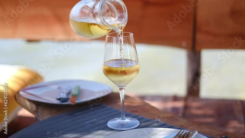 Home white wine pouring into a glass on a beach, Albania. High quality 4K footage photo
