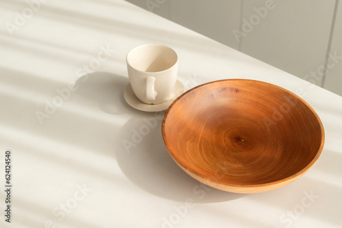 Step into elegant and clean kitchen with vintage charm. Simple and bright, round wooden tableware and utensils create still life of simplicity. hand made coffee cup and bowl.
