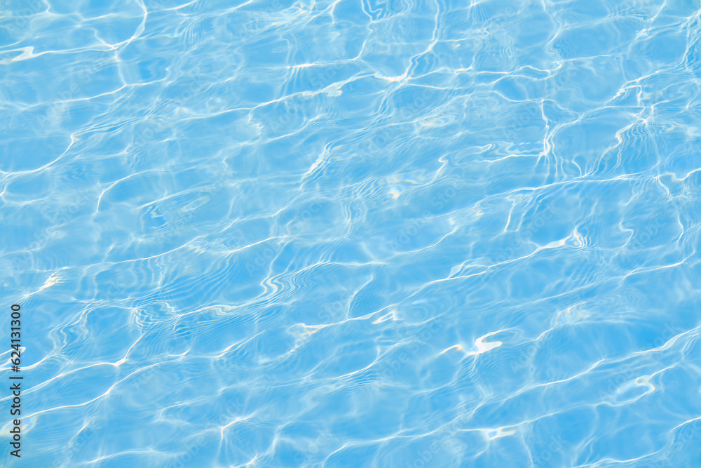 Defocused blurred transparent blue colored clear calm water surface texture with ripple. Shining blue water background. Water in swimming pool.
