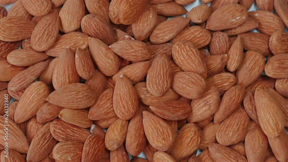 Close-up of organic, peeled almonds falling on table.. Nutty, crunchy snack packed with protein and vitamins. Concept of healthy eating and nutrition.