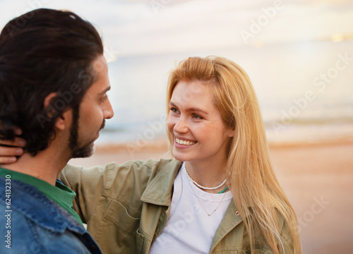 Happy Young Couple Embracing While Having Romantic Date On The Beach
