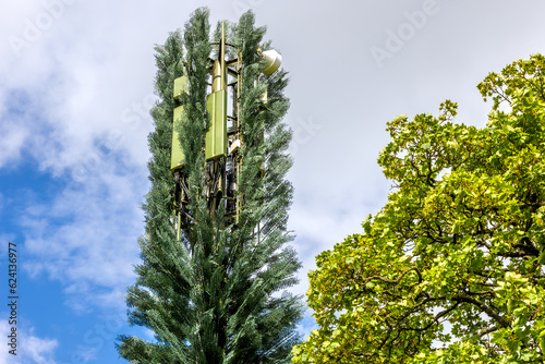 Mobile telecommunication cell tower disguised as a tree, camouflaged gsm antenna. photo