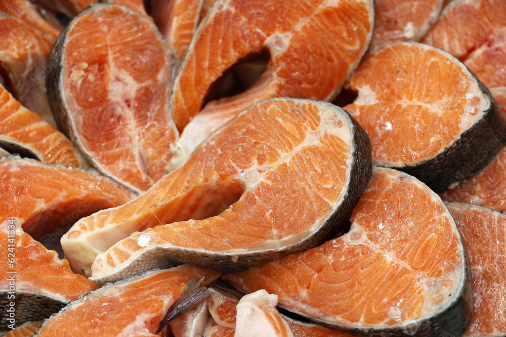 Fresh pink salmon steaks in the ice. Red fish in the market, concept of healthy food with omega fats, fishing industry Fresh pink salmon steaks in the ice. Red fish in the market, concept of healthy food with omega fats, fishing industry