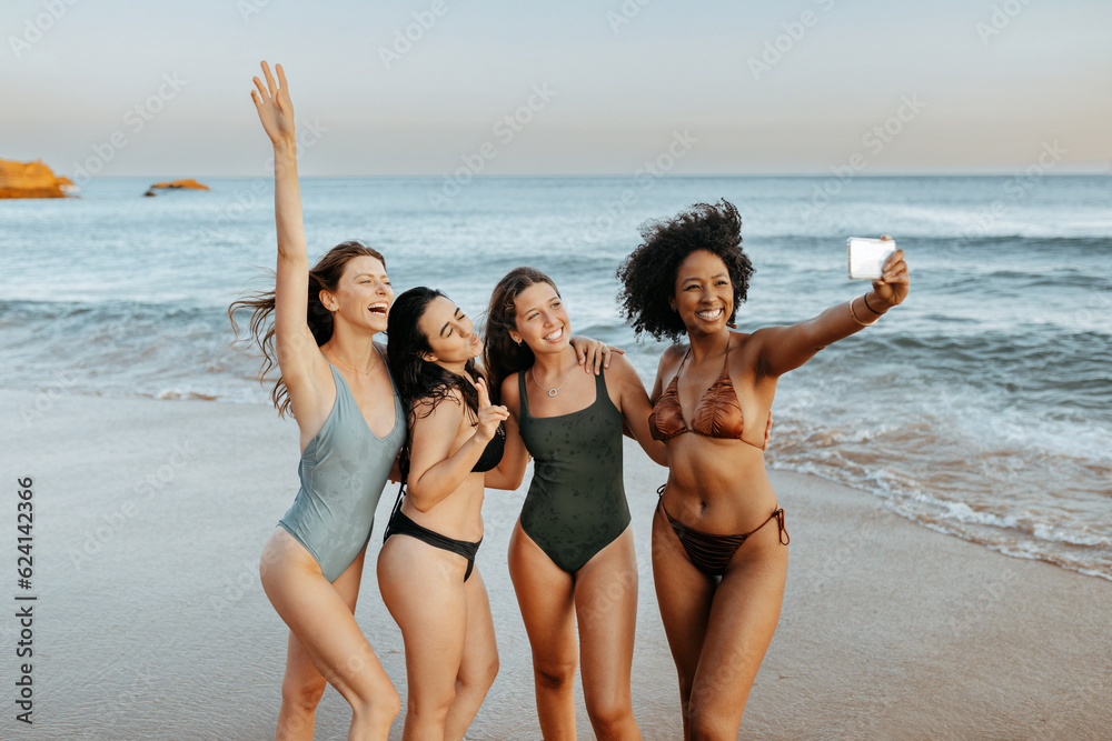 Capturing summer vacation time. Carefree diverse women taking picture together at the beach, making memories Capturing summer vacation time. Carefree diverse women taking picture together at the beach, making memories