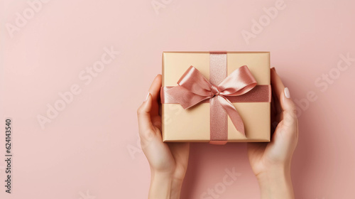 Holiday minimal background with hands holding gold gift box, Christmas Day and New Year concepts, happiness moment. Generative AI. © Sunshinemeee