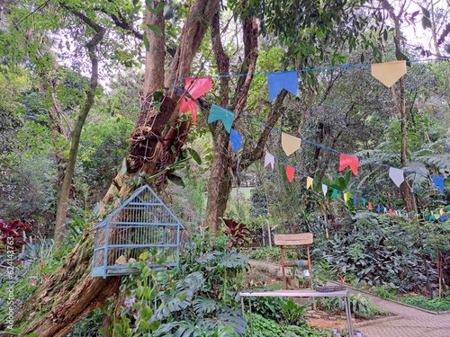 Guarulhos, São Paulo, Brazil - June 30, 2022. View of garden decorated with pennants, table, chair and birdcage in Bosque Maia. photo