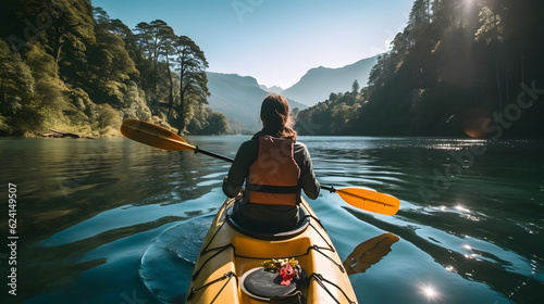 Fotografia Rear view of woman riding kayak in stream with background of beautiful landscape