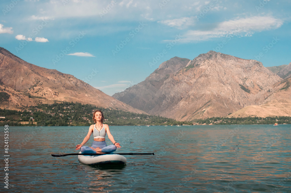 Woman on sup board. Mountain background. Healthy lifestyle