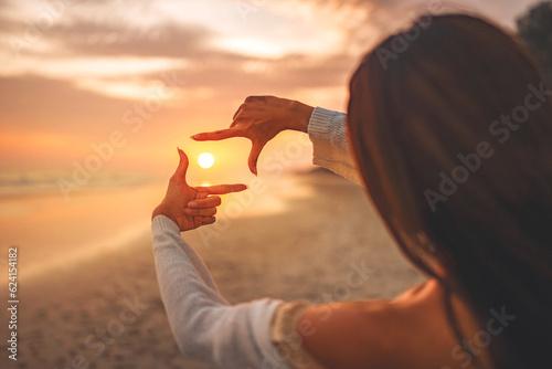 Travel planning concept, Close up of tourist woman hands making frame gesture on the sea beach with sunset, Female capturing the sunrise.