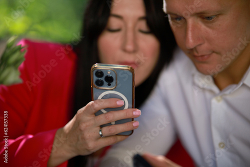 Happy couple using phones outdoors and looking at phone screens