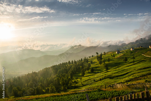 View of the mountains and mountain village with wooden fence during sunset and beautiful sky. Evening landscape in a mountain Georgian village. Svaneti, Georgia