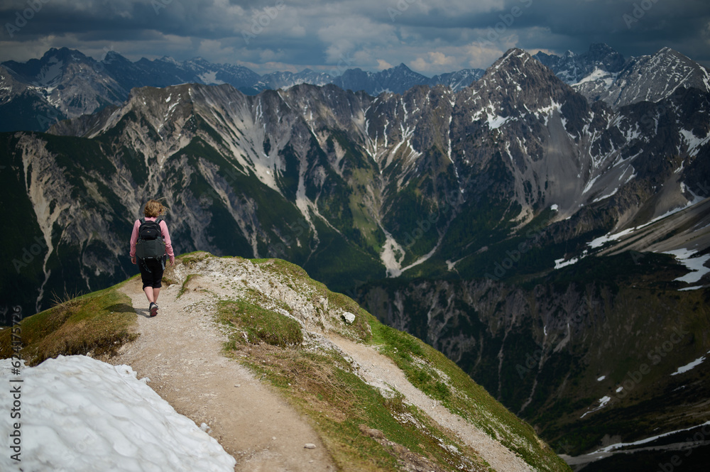 Woman hiking on a mountain-top trail in the Austrian Alps