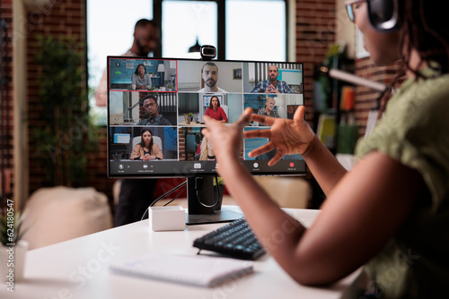 Fotografija African american startup employee working from home gesturing in video conference with colleagues at desk
