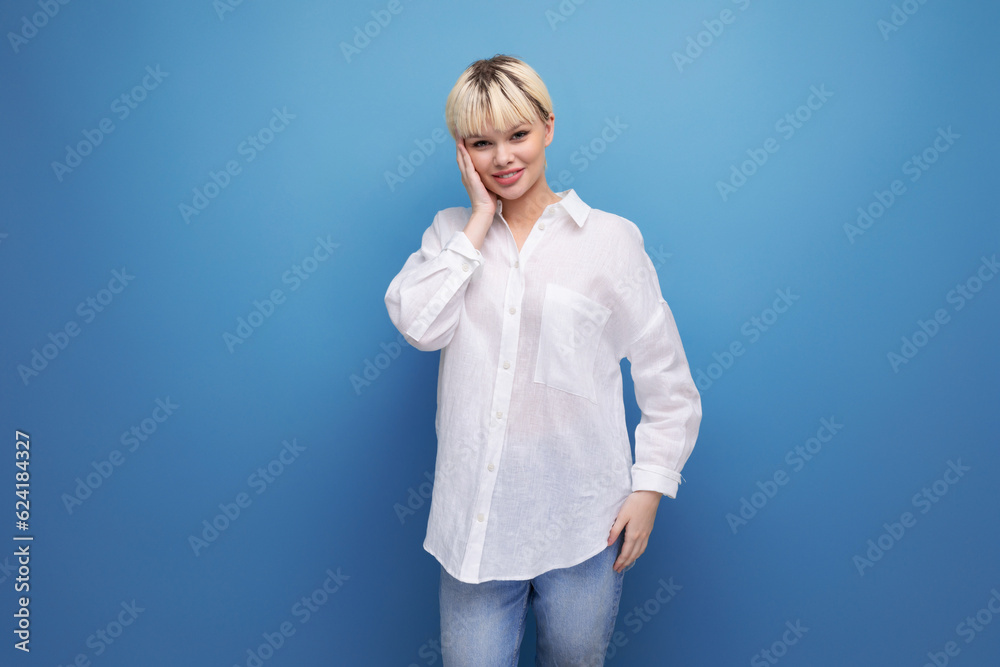 young pretty blond career woman in a white shirt posing on a blue background with copy space. people lifestyle concept