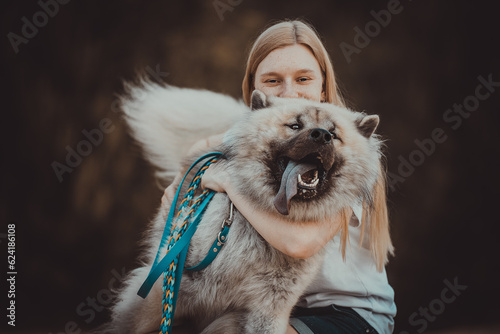 Frau umarmt glücklichen Eurasier Hund