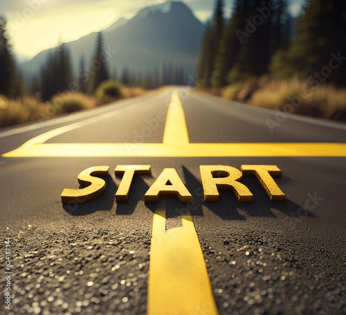  The word start written in yellow on black asphalt on a road leading to high mountains. The concept of beginnings, new projects, new challenges, new year.