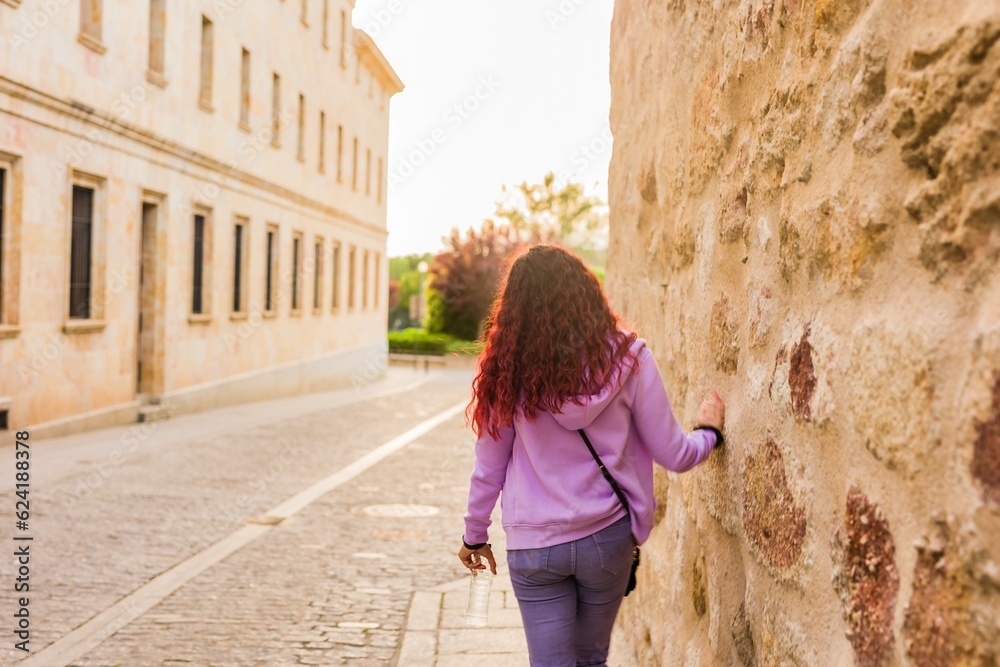 Fototapeta premium Unrecognizable female back view travel vacation, explore city of Spain. Salamanca tourist