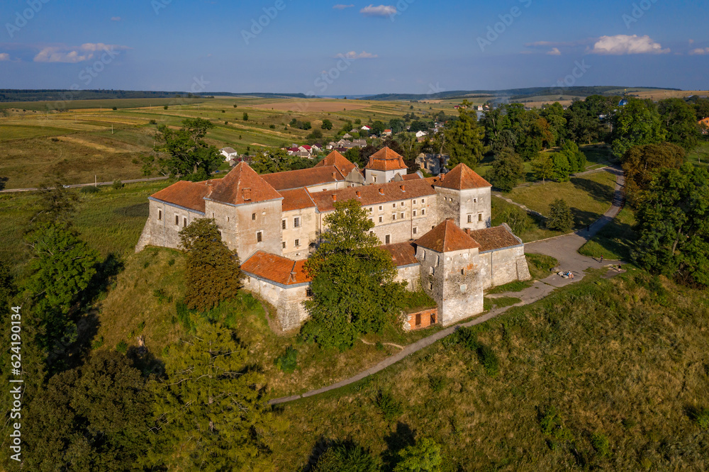 Scenic aerial view on medieval castle on lake shore. Location place: Svirzh, Ukraine. View from flying drone quadcopter.