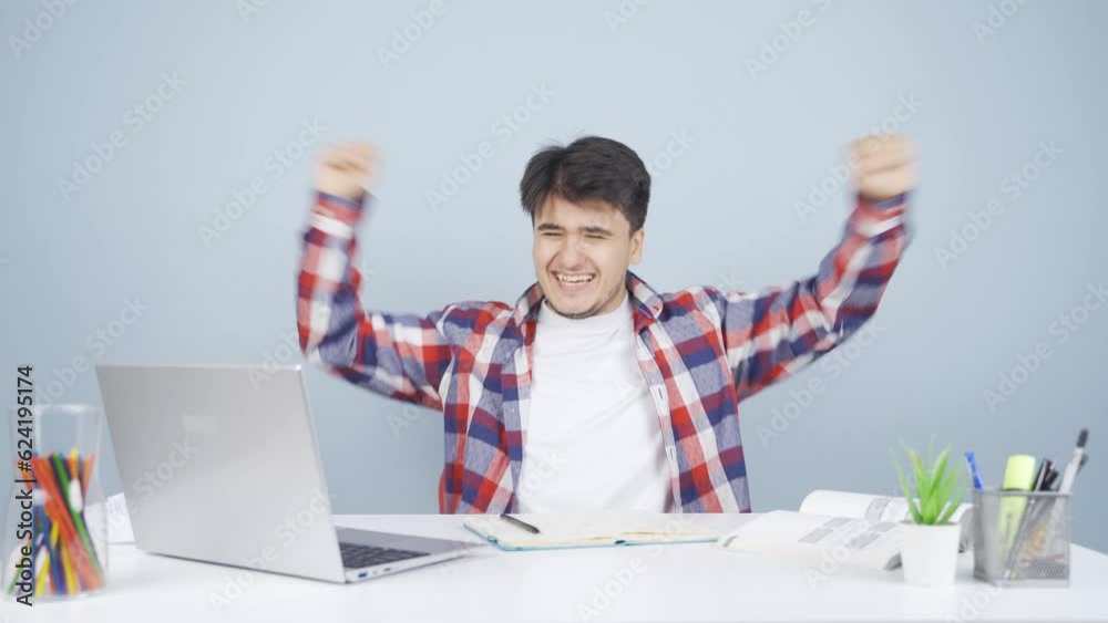 Man looks at laptop and rejoices.