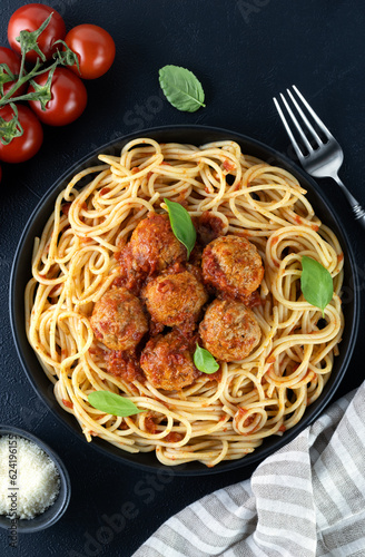 Spaghetti with meatballs and parmesan cheese on a black background. Top view. Italian food.