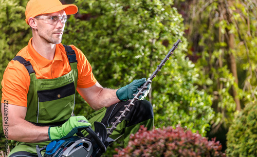 Foto Professional Gardener with His Powerful Shrub Trimmer