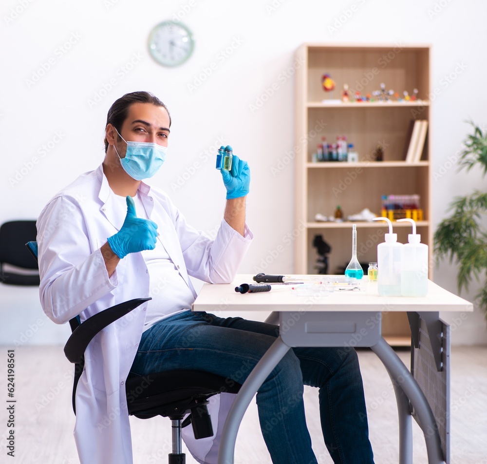 Young male chemist working in the lab during pandemic