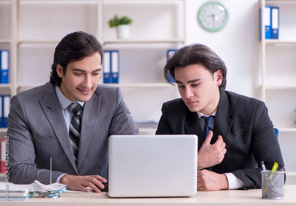 Obraz premium Two young employees working in the office