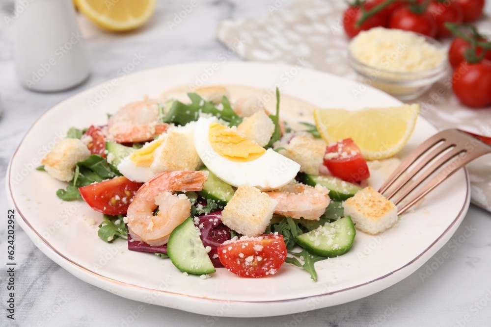 Delicious Caesar salad with shrimps on white marble table, closeup