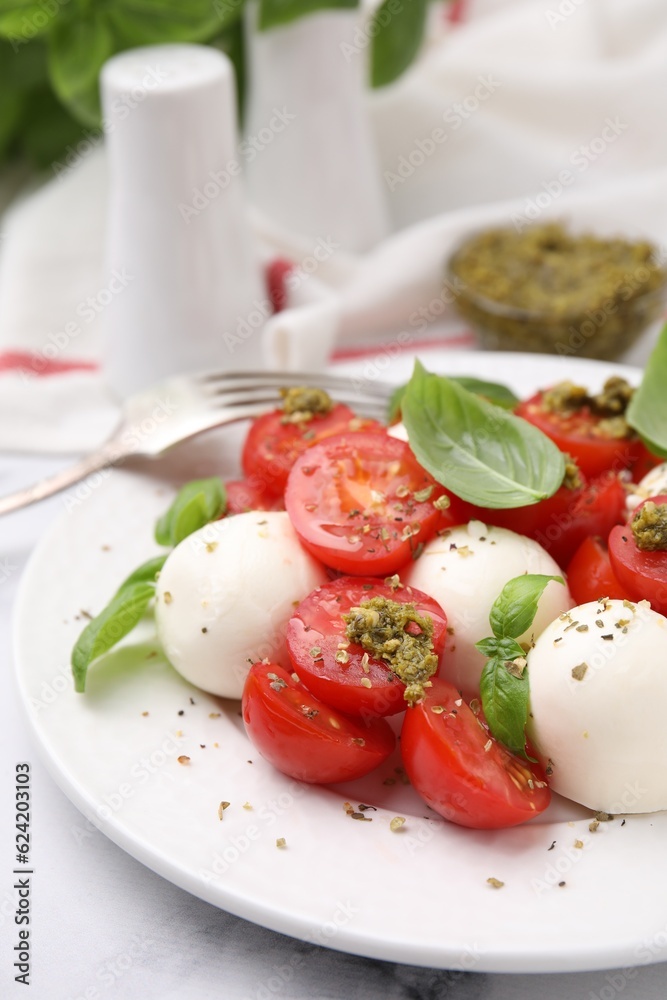 Tasty salad Caprese with tomatoes, mozzarella balls and basil served on table, closeup Tasty salad Caprese with tomatoes, mozzarella balls and basil served on table, closeup