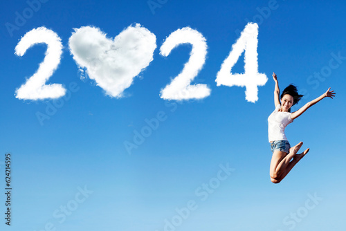 Excited asian woman is jumping with new year 2024 on the clear sky
