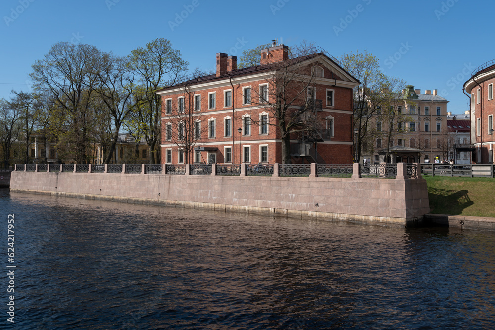 View of a brick building, formerly the commandant's house, on the island of New Holland on the banks of the Moika River on a sunny day, St. Petersburg, Russia