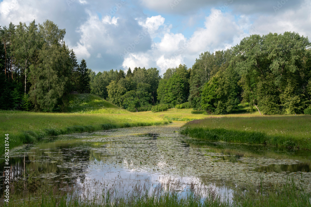 Slavyanka River Valley in the landscape part of the Pavlovsk Palace and Park Complex on a sunny summer day, Pavlovsk, Saint Petersburg, Russia Slavyanka River Valley in the landscape part of the Pavlovsk Palace and Park Complex on a sunny summer day, Pavlovsk, Saint Petersburg, Russia