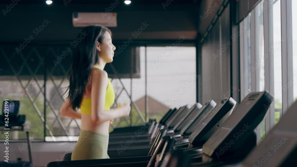 Young Asian Woman Running on Treadmill - Fitness Gym Exercise Young Asian Woman Running on Treadmill - Fitness Gym Exercise