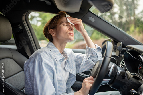 Foto Woman drives car with broken air conditioning in hot summer weather