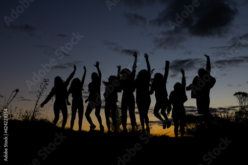 Grupo de chicas saltando a contraluz en el atardecer