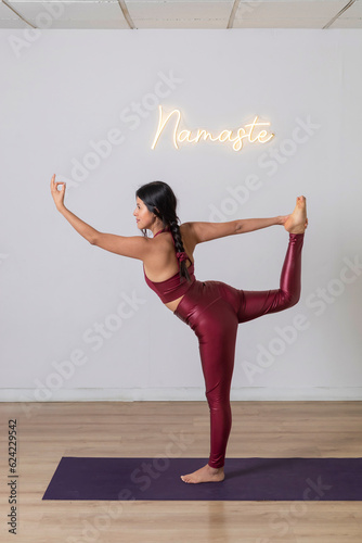 Woman doing a balancing pose while practicing yoga in a studio. Tuladandasana photo
