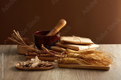 Front view of ginseng roots on tray, rhizoma rhe and codonopsis pilosula displayed on wooden table. Healthy herbs. Advertisement scenes for traditional Chinese medicines photo
