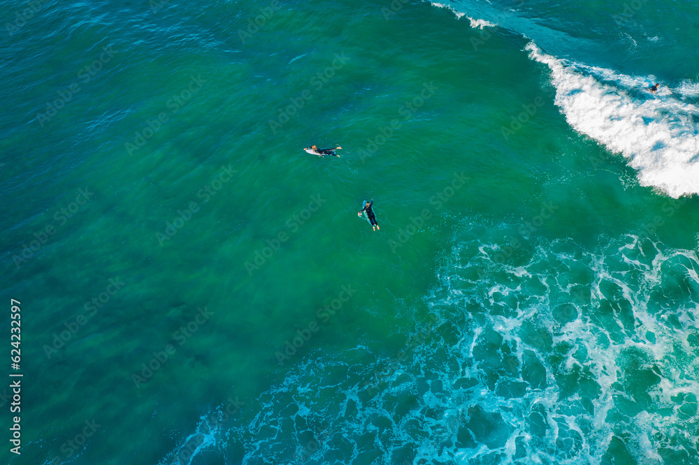 Drone aerial view over group of surfers