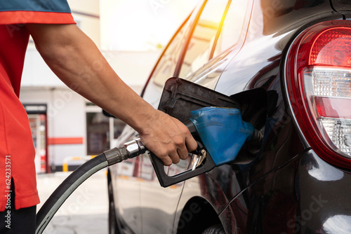 Car refueling on petrol station. Fuel pump at station. Refueling the car at a gas station fuel pump. Man driver hand refilling and pumping gasoline oil