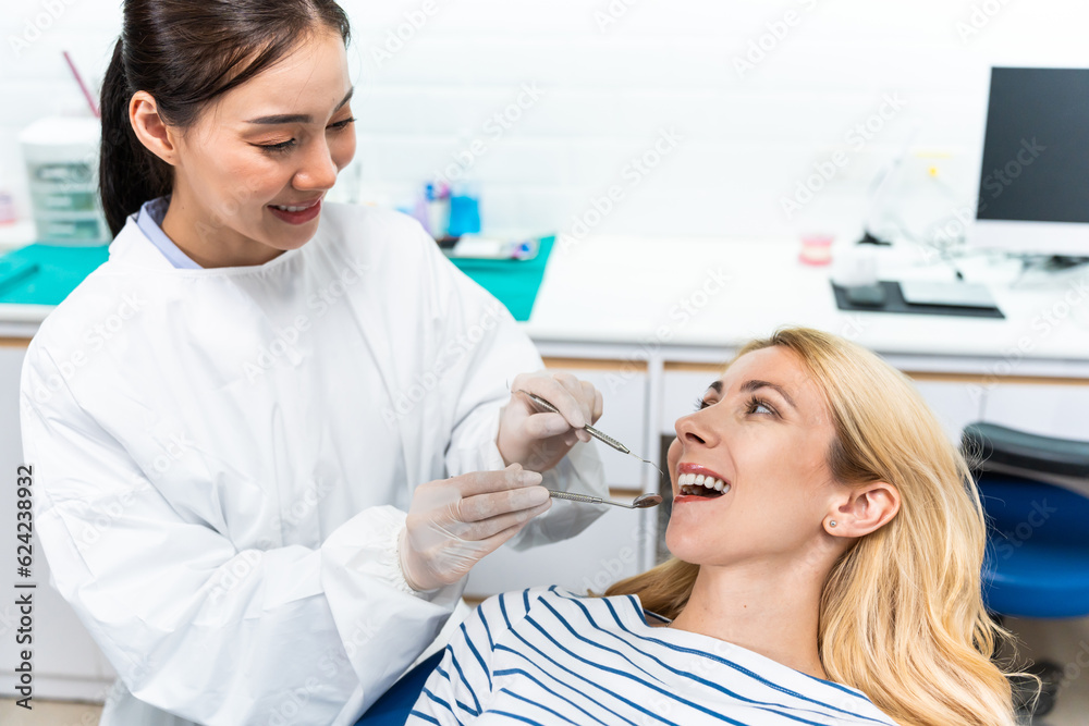 Female dentist examine tooth to Caucasian girl at dental health clinic. Female dentist examine tooth to Caucasian girl at dental health clinic.