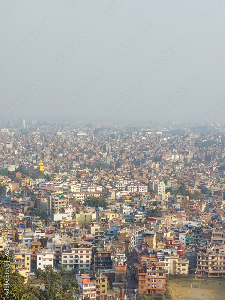 View of the Kathmandu city from the top of the Syambhunath temple, showing the congested buildings with some trees. Kathmandu city