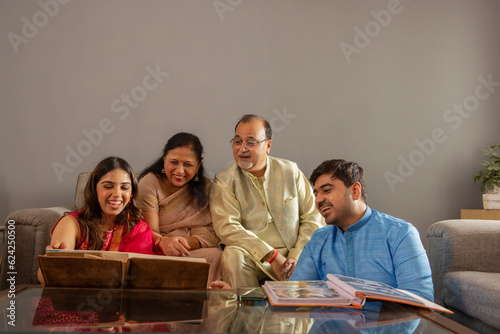 Happy Indian family watching photo album together at home