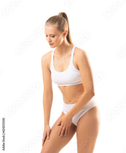Young and beautiful slender girl in white swimsuit posing over white background. Healthcare, diet, sport and fitness concept.