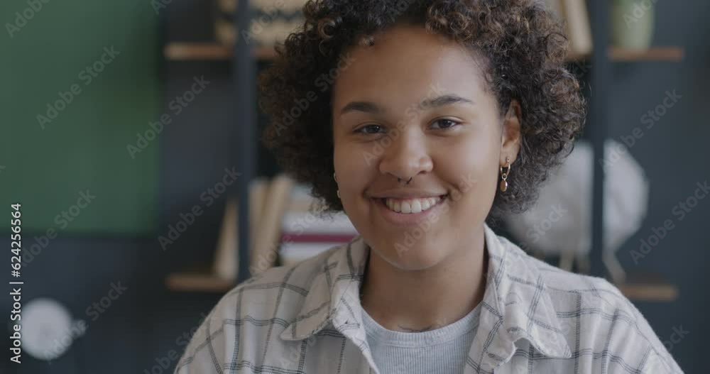 Slow motion portrait of joyful office worker African American woman smiling looking at camera in workplace. Positive emotion and job concept. Slow motion portrait of joyful office worker African American woman smiling looking at camera in workplace. Positive emotion and job concept.