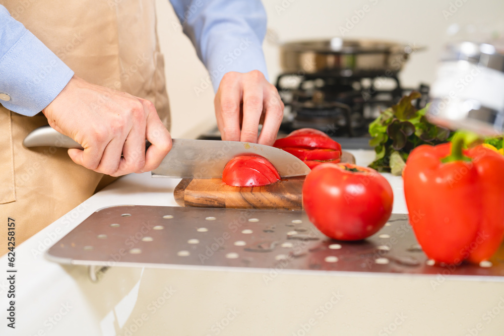 トマトを切る若い男性　料理イメージ	
