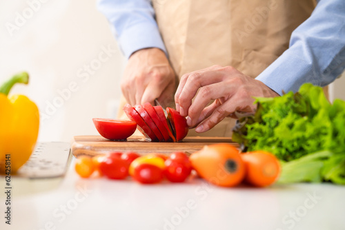 トマトを切る若い男性　料理イメージ	
 photo