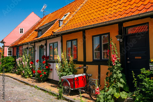 Yellow house and hollyhocks in Rønne, Bornholm Island in Denmark with bike and cart. photo