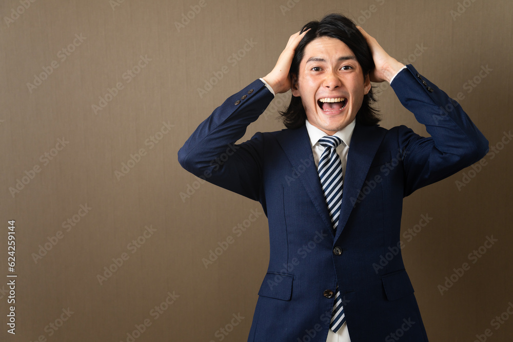 頭を抱える若いビジネスマン 頭を抱える若いビジネスマン